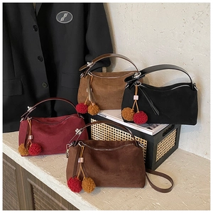 Détail de quatre sacs polochon en daim de couleurs automnales avec breloques en peluche