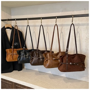 Détail de sacs fourre-tout vintage en daim aux tons terreux avec texture plissée