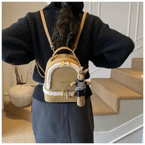 Detailansicht des khakifarbenen Mini-Rucksacks mit Pelzbesatz und Hasenanhänger