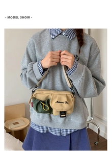Detail of khaki and green canvas crossbody bag featuring Mebern Bag embroidery and buckle