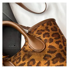 Close-up of leopard print suede bucket bag showing leather handles and fine stitching
