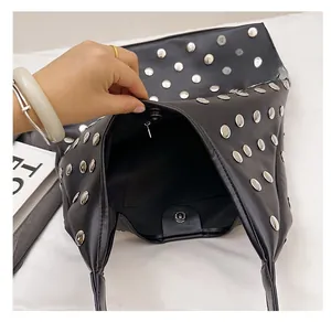 Interior view of black rivet underarm bag showing spacious compartment and silver stud detail