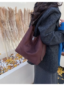 Close-up of dark brown suede bucket bag with silver metal swivel lock for autumn style
