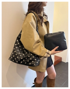 Close-up of black rivet tote bag and clutch set with silver metal studs in street style