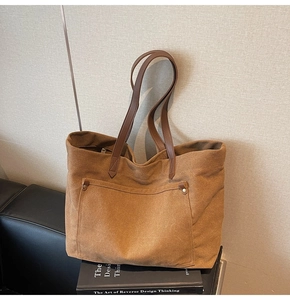 Close-up of vintage large capacity brown canvas tote bag with leather straps and rivets