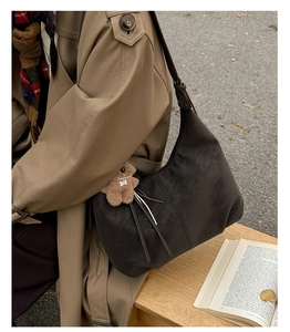 Détail du sac hobo vintage en cuir marron avec breloque ours et fermeture éclair
