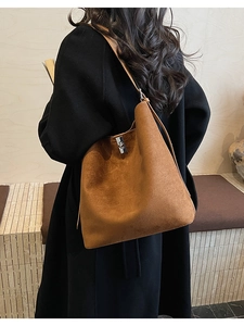 Detailed view of brown matte bucket bag showing textured finish and silver metal buckle