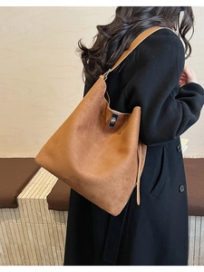 Detailed view of brown suede hobo bag with a silver metallic twist lock and leather strap
