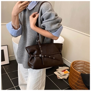 Détail du sac cabas en similicuir marron foncé avec œillets métalliques et lanière