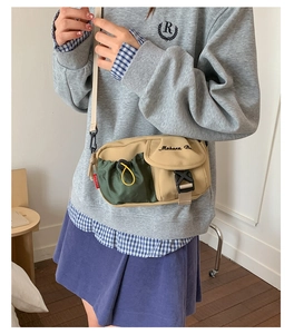 Detail der khakifarbenen Segeltuchtasche mit dunkelgrüner Kordeltasche und Schnalle