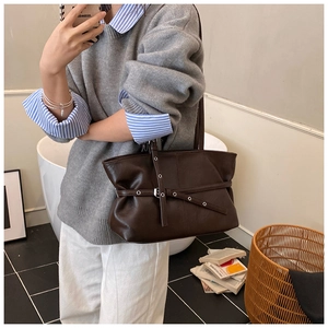 Détail du sac cabas marron foncé avec sangle à œillets et finition mate élégante