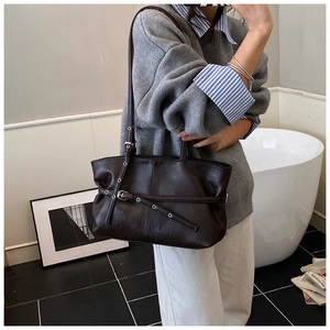 Détail du sac cabas en daim marron chocolat avec texture plissée et sangle à boucle métal