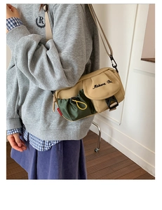 Detail of khaki and green nylon crossbody bag with flap cover and side drawstring pocket