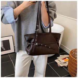 Détail d'un grand sac cabas en similicuir marron foncé avec boucles et sangles réglables