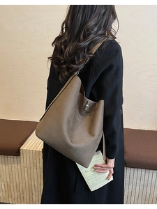 Close-up of brown frosted leather bucket bag featuring a silver metal twist-lock closure