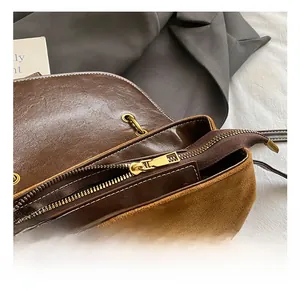 Dettaglio della trama mista in pelle vintage marrone e camoscio con cerniera dorata