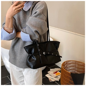 Détail du sac cabas plissé en similicuir noir avec œillets métalliques sur modèle