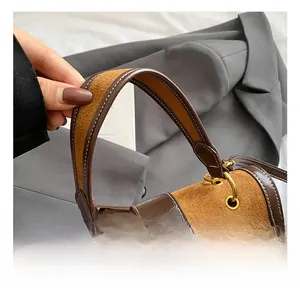 Dettaglio borsa a sella vintage in pelle e scamosciato con anello in oro e manico