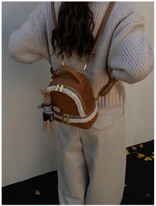 Brown suede backpack with faux shearling trim and bunny plush detail on model