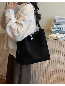 Detail of silver twist lock and matte texture on a black oversized bucket shoulder bag