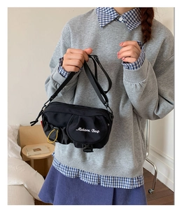 Detail of black waterproof nylon crossbody bag with Moborn Bag embroidery and yellow drawstring