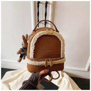 Detail of brown faux suede mini backpack with fleece trim and a cute rabbit charm
