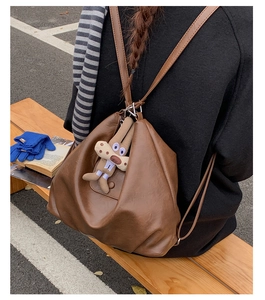 Detail view of deep brown soft leather backpack with cute bunny charm in winter setting
