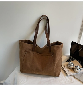 Detail of vintage brown suede tote bag with metal rivet pocket and leather straps