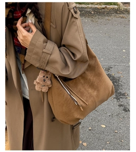 Sac sous le bras en daim marron avec charme d'ours sur mannequin en manteau kaki