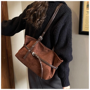Détail du sac cabas en daim marron foncé avec sangle en cuir et boucle en métal