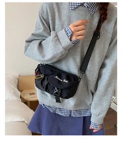 Detail of black crossbody bag with white Moborn Bag embroidery and adjustable strap