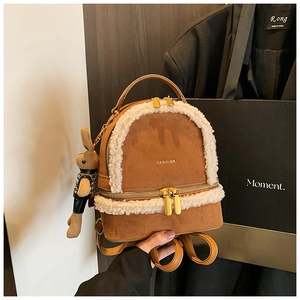 Detail of brown faux suede backpack with white faux fur trim and cute bunny charm