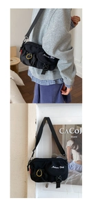 Close-up of black tactical crossbody bag with white embroidery and yellow ring detail