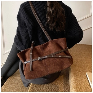 Vue détaillée du sac cabas en daim marron foncé avec sangles décoratives en cuir
