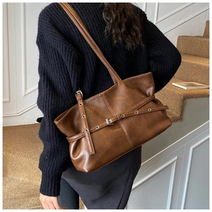Détail du sac cabas marron vintage avec texture mate, ceintures décoratives et boucles