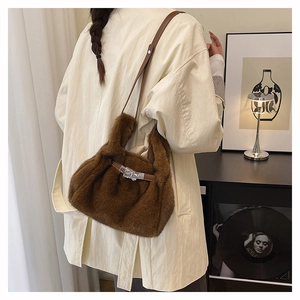 Détail du sac à main en peluche marron avec lanières en cuir et fermoir argenté