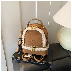 Close-up of brown suede mini backpack with white faux fur trim and rabbit charm