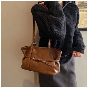 Gros plan du sac cabas rétro marron avec sangles à boucles et détails de couture vintage
