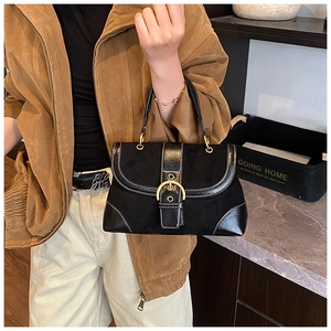 Close-up of black retro saddle bag featuring large metal buckle and white contrast stitching