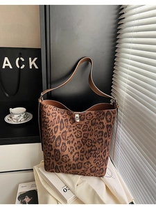 Detail of leopard print bucket bag featuring brown leather trim and silver twist-lock closure