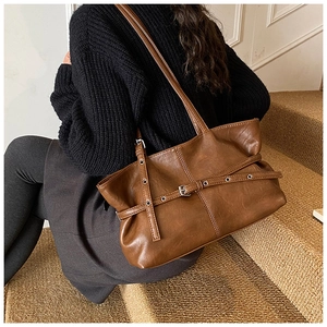 Détail du sac cabas marron vintage avec œillets argentés et lanières à boucles