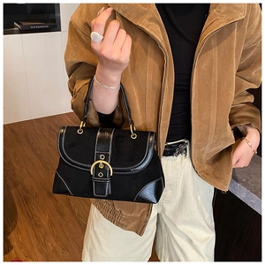 Detailed view of black vintage saddle bag with white stitching and gold buckle closure