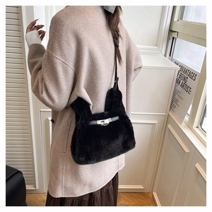 Détail du sac à main en peluche avec fermoir métallique sur un manteau beige