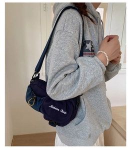 Detail view of navy nylon crossbody bag with Moborn Bag logo and adjustable drawstring