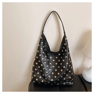 Close-up of black hobo bag with silver metallic rivets on premium textured leather