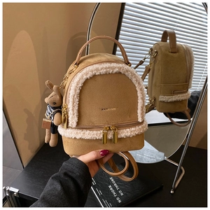 Detailed close-up of brown plush backpack with white lamb wool trim and rabbit keychain