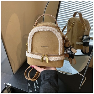 Detail of khaki suede mini backpack with white faux fur trim and cute rabbit charm