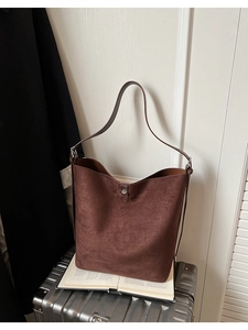 Detail of vintage matte brown bucket bag with adjustable strap and silver metal buckle