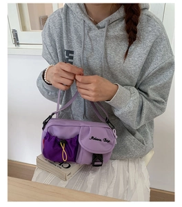 Detail view of purple multi-pocket crossbody bag with mesh drawstring and Mobern Bag logo