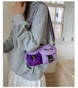 Detail der lila Nylon-Umhängetasche mit Mesh-Kordelzugtasche und Schnallenverschluss